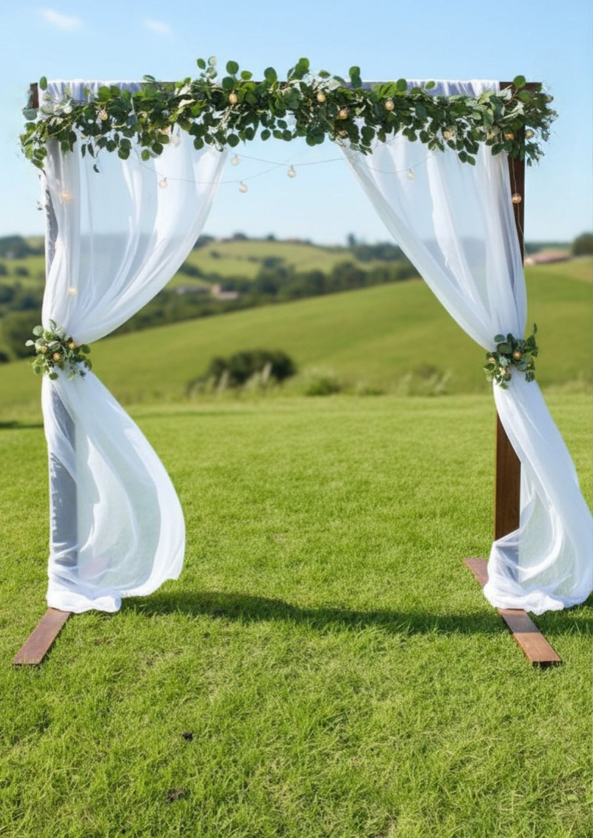 Square arch with sheer white drapes and greenery